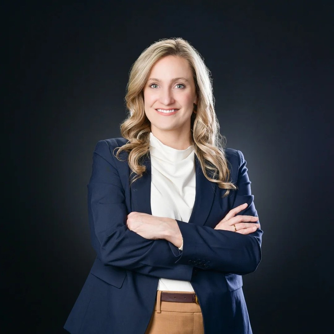 Cassandra Rice in a navy blazer with arms crossed, smiling in a professional portrait